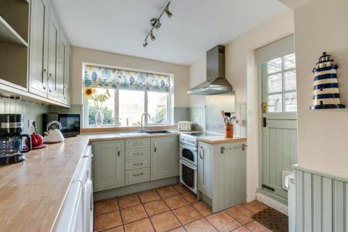 a kitchen with white cabinets and a sink at 30 Victoria Street in Southwold