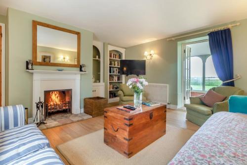 a living room with a fireplace and a couch at Three Ash Farm in Bungay