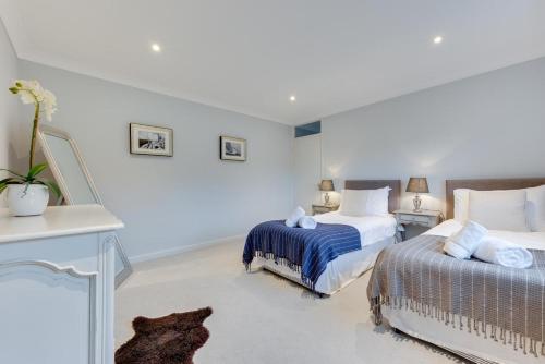 two beds in a room with white walls at Dakings in Halesworth