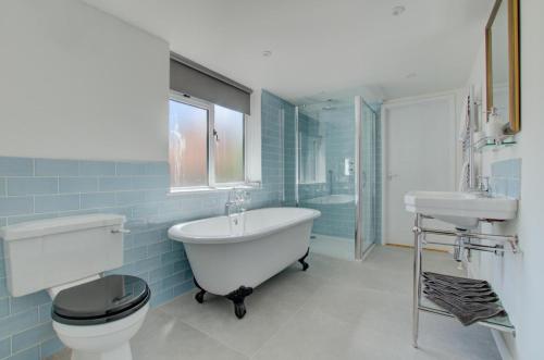 ein Badezimmer mit Badewanne, Toilette und Waschbecken in der Unterkunft James Cottage in Southwold