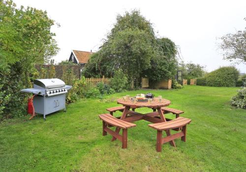 a picnic table and a grill in a yard at Old Brewery House in Orford
