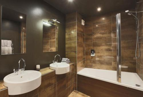 a bathroom with two sinks and a bath tub at Stone Farm in Lavenham