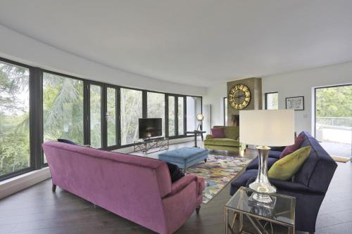 a living room with purple furniture and large windows at Stone Farm in Lavenham
