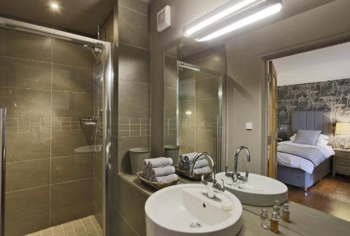 a bathroom with a sink and a shower and a bed at Stone Farm in Lavenham