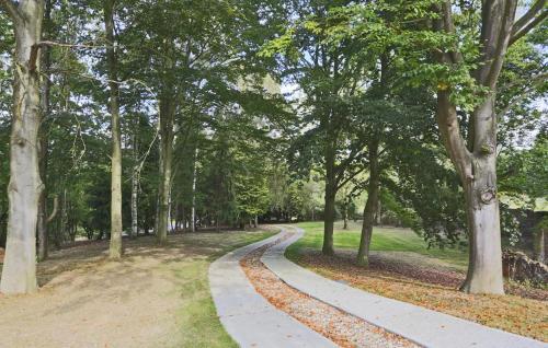 a path in a park with trees and leaves at Stone Farm in Lavenham