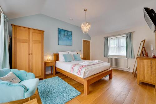 a bedroom with a bed and a couch and a chair at Woodland Lodge in Wilby