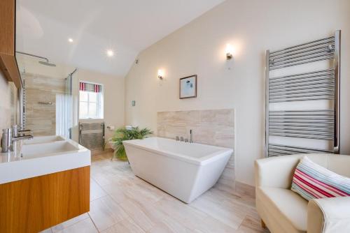 a large bathroom with a tub and a sink at Woodland Lodge in Wilby