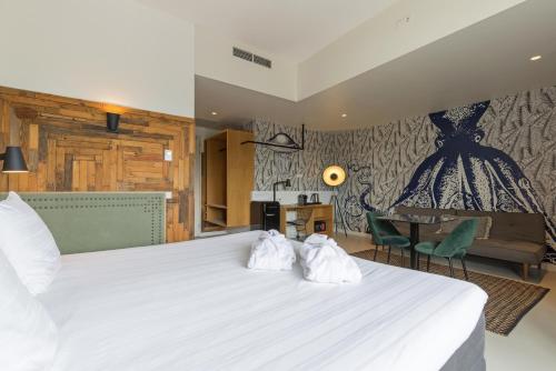 a bedroom with a large white bed with two towels at Leonardo Hotel Vinkeveen Amsterdam in Vinkeveen