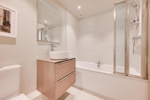 a bathroom with a sink and a toilet and a tub at Rose Cottage in Middleton