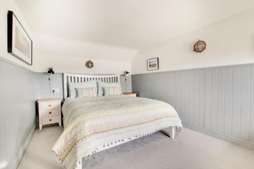 een witte slaapkamer met een bed en een witte muur bij Box Cottage in Snape