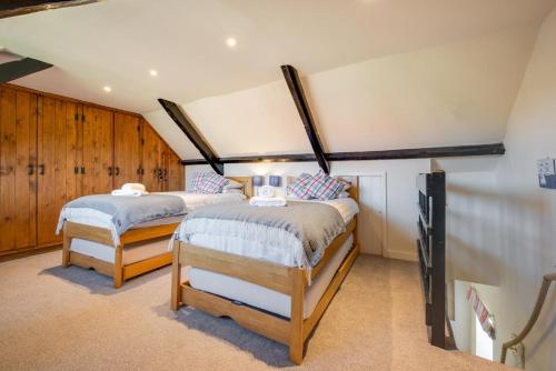 2 Betten in einem Zimmer mit Holzschränken in der Unterkunft Fishermen's Cottage in Sheringham