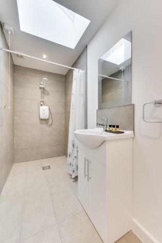 a white bathroom with a sink and a shower at 6 Bed in Great Waldingfield oc-ac4 in Waldingfield