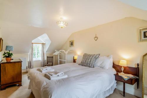 a bedroom with a large bed with two towels on it at Vine Cottage in Walberswick