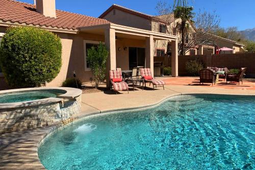 a swimming pool in front of a house at Bedrock Lane in Oro Valley