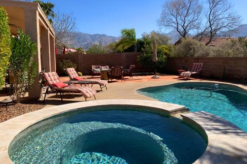 a swimming pool in a yard with chairs and a table at Bedrock Lane in Oro Valley