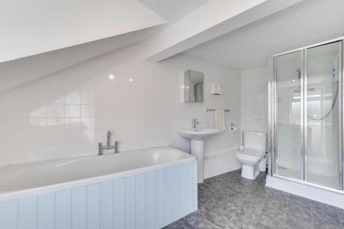 Un baño con bañera, lavabo e inodoro. en Morte View, en Mortehoe