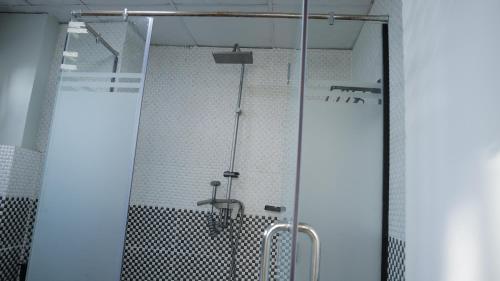 a shower with a glass door in a bathroom at My dream apartment in Addis Ababa