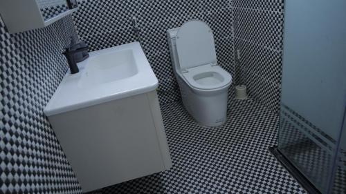 a bathroom with a white toilet and a sink at My dream apartment in Addis Ababa