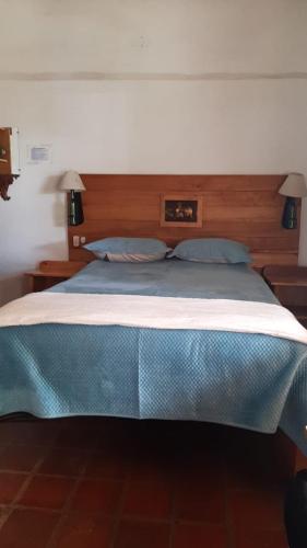 a bedroom with a bed with a blue blanket on it at The Black Sheep Inn in Chugchilán