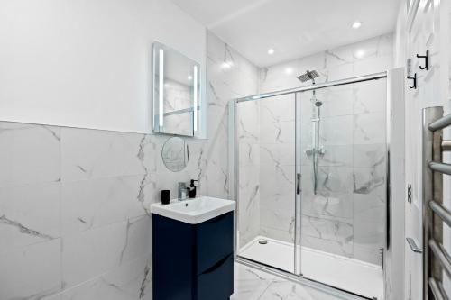 a white bathroom with a shower and a sink at The Lanes Brighton Short Stay 2Bed 2Bath Sleeps 8 in Brighton & Hove