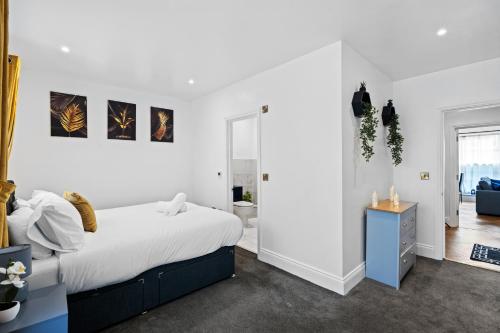 a white bedroom with a large bed and a blue cabinet at The Lanes Brighton Short Stay 2Bed 2Bath Sleeps 8 in Brighton & Hove