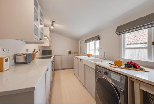 a kitchen with a washing machine in the middle of it at London Cottage in Halesworth