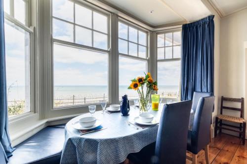 a dining room with a table with a view of the ocean at Two The Crescent in Cromer
