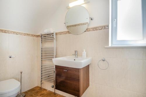 une salle de bain avec un lavabo et un miroir au mur dans l'établissement Fishermans House, à Sheringham