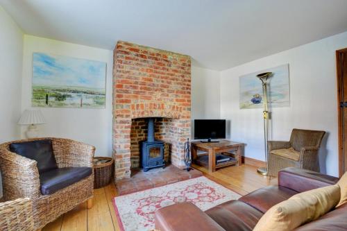 a living room with a brick fireplace and a couch at 17 The Green in East Rudham