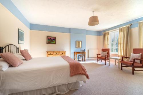 a bedroom with a bed and a desk and chairs at The Old Rectory in Tattingstone