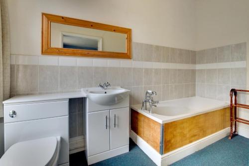a bathroom with a sink and a tub and a toilet at The Old Rectory in Tattingstone