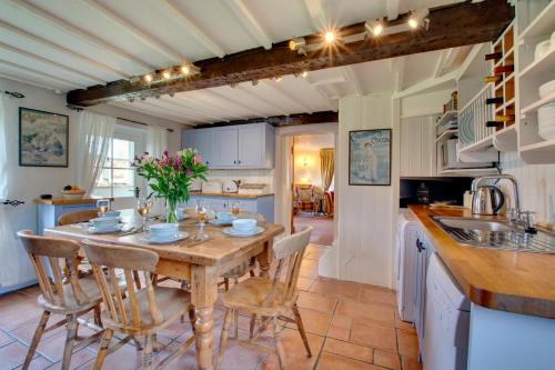 a kitchen with a wooden table and chairs in a kitchen at Cockleshells in Castle Acre