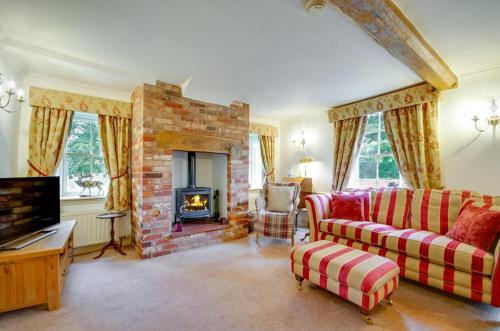 a living room with a couch and a fireplace at Cockleshells in Castle Acre
