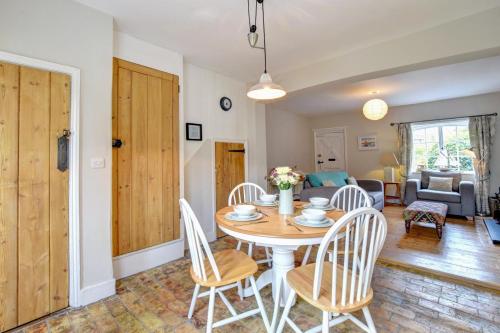 a dining room and living room with a table and chairs at The Lobster Pot in Orford