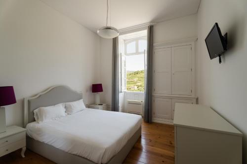 Un dormitorio blanco con una cama blanca y una ventana. en Casa de Cambres - by RowdHouses, en Lamego