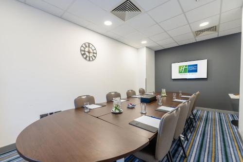 a conference room with a large wooden table and chairs at Holiday Inn Express Aberdeen Airport by IHG in Dyce