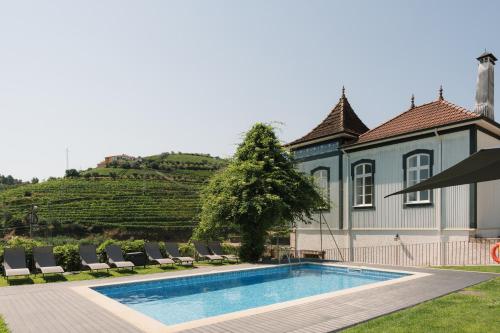 a villa with a swimming pool in front of a house at Casa de Cambres - by RowdHouses in Lamego