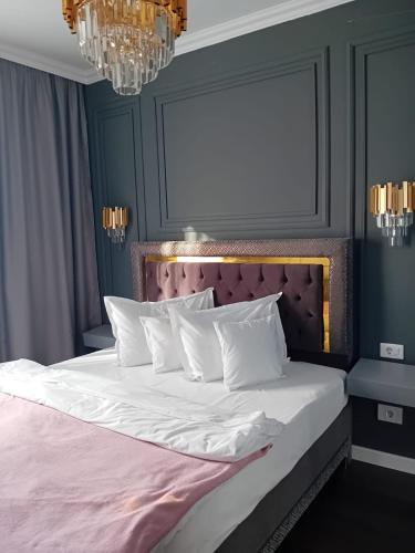a bedroom with a white bed with a pink headboard at Gloria Golden Suite- Luxury&Designe Experience in Oradea