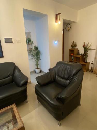 a living room with a leather chair and a couch at 2BHK Lakeview Apartment in chennai in Siruseri