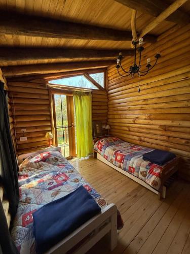 a bedroom with two beds in a log cabin at Sweet Home 1 in Tigre