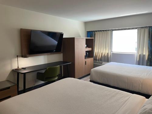 a hotel room with two beds and a desk with a television at Comfort Inn Downtown Charleston in Charleston
