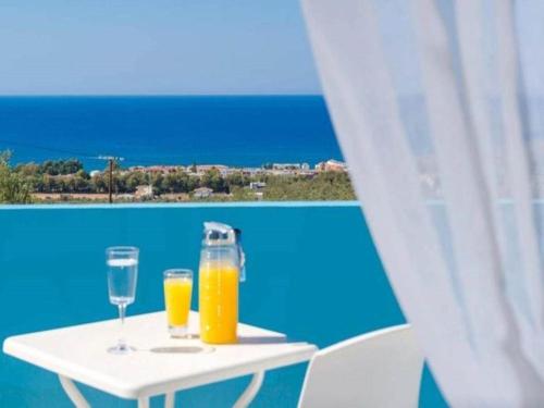 a table with two glasses of orange juice on it at Carme Villas in Adelianos Kampos