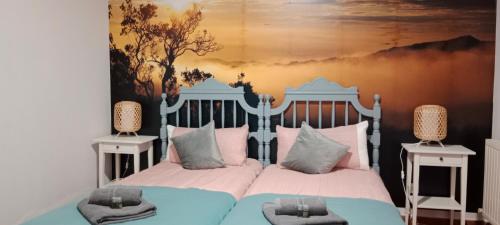 a bedroom with a blue and white bed with two night stands at Pension Urries 