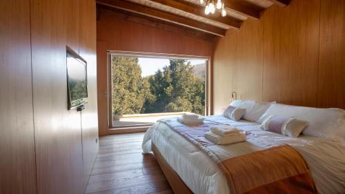 a bedroom with a large bed with a large window at Stunning 4-Bedroom House Large Garden and Pool H61 by Apartments Bariloche in San Carlos de Bariloche
