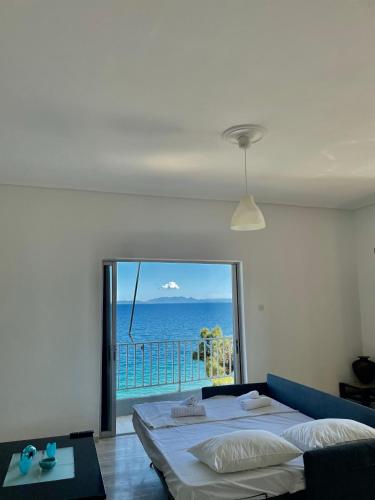 a bedroom with a bed and a view of the ocean at Apartment above the sea in Agioi Theodoroi