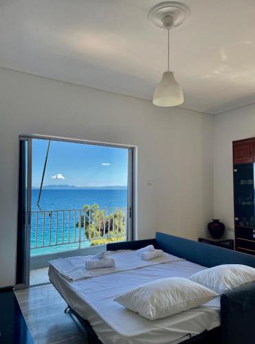 a bedroom with a bed with a view of the ocean at Apartment above the sea in Agioi Theodoroi