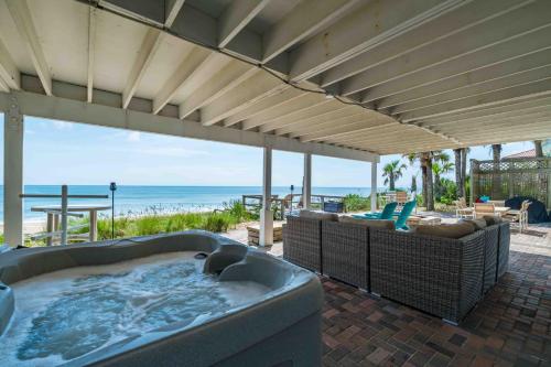 a hot tub on a patio with a view of the beach at Gone Coastal - Oceanfront Home with a Hotub in Ponte Vedra Beach