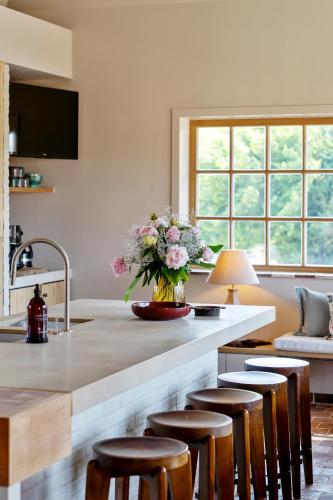 a kitchen with a counter with a vase of flowers at Ferme Gisèle gastenverblijven in Diksmuide