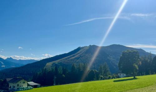 a view of a green field with mountains in the background at Ferienhaus Korda in Ramsau am Dachstein