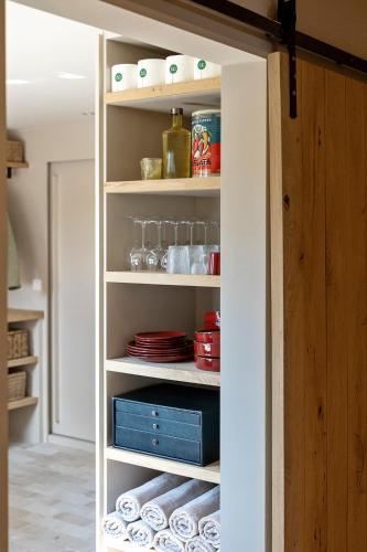 a pantry with plates and dishes on shelves at Ferme Gisèle gastenverblijven in Diksmuide